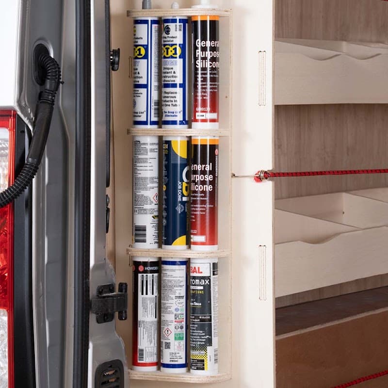 Vertical storage unit with various spray cans neatly organized in a van, showcasing racking and accessories for efficient use.