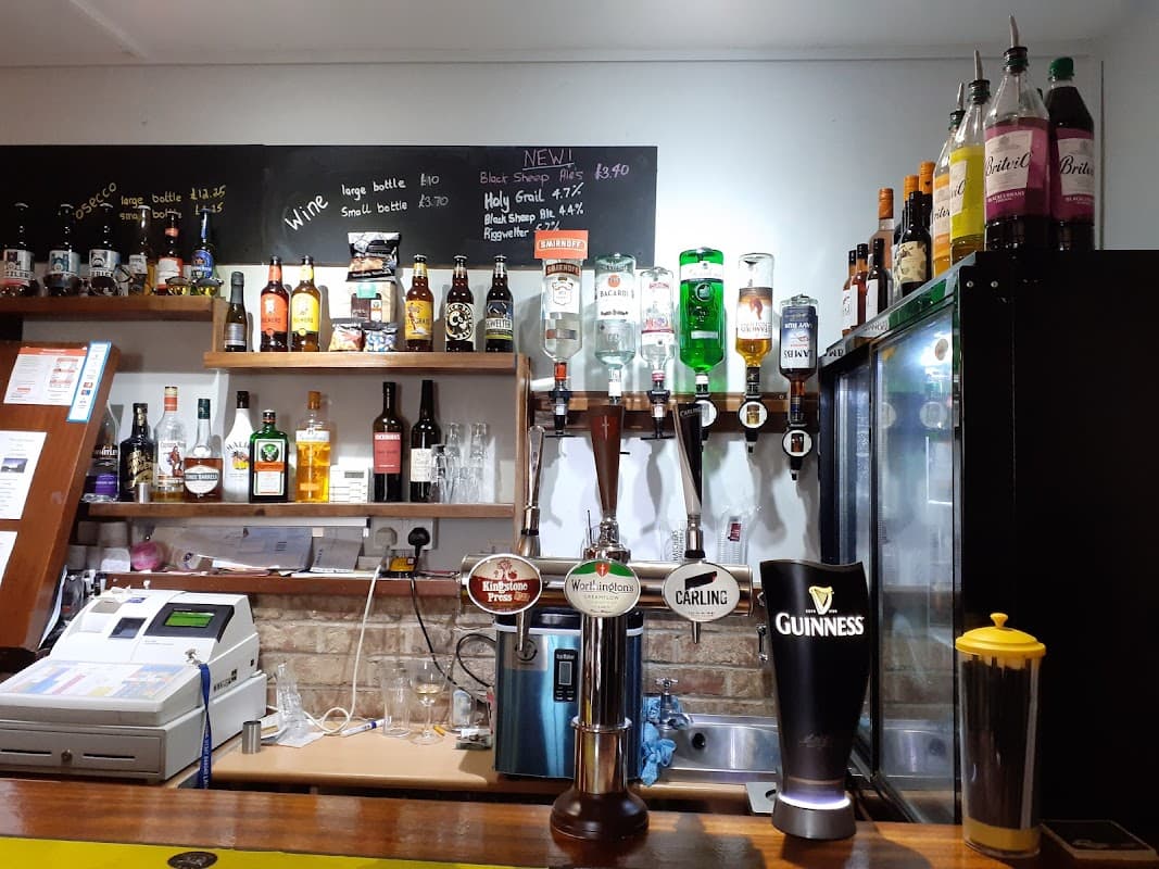 Bar counter with various beer taps, a selection of spirits, and a chalkboard menu at Linton Lock Inn.