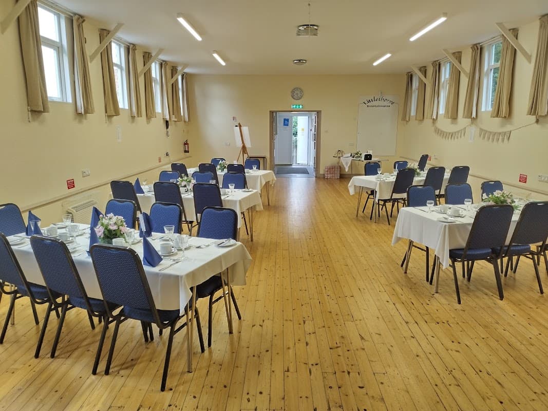 Interior of Littlethorpe Village Hall with neatly arranged tables, chairs, and floral centerpieces, ready for an event.