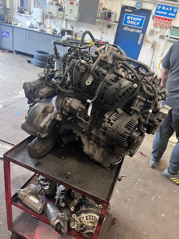 Engine on a workbench in a garage, with tools and equipment visible in the background.