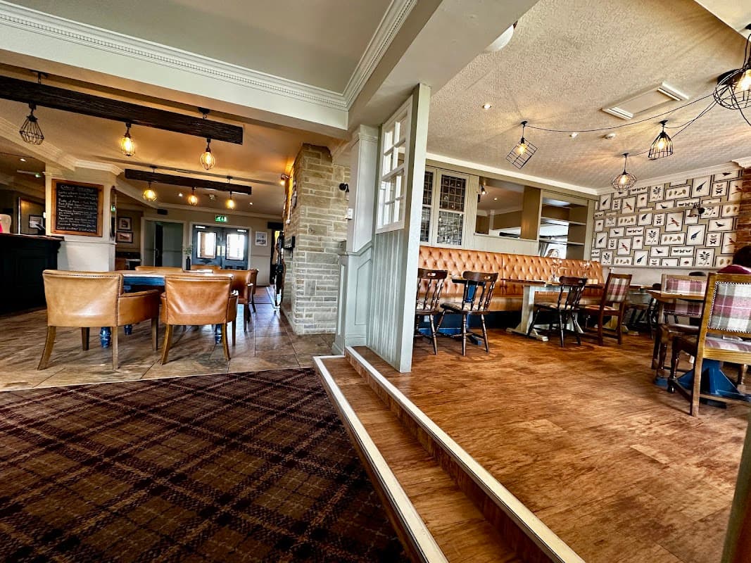 Cozy restaurant interior with wooden flooring, leather seating, and decorative wall art in Low Worsall, Yorkshire.