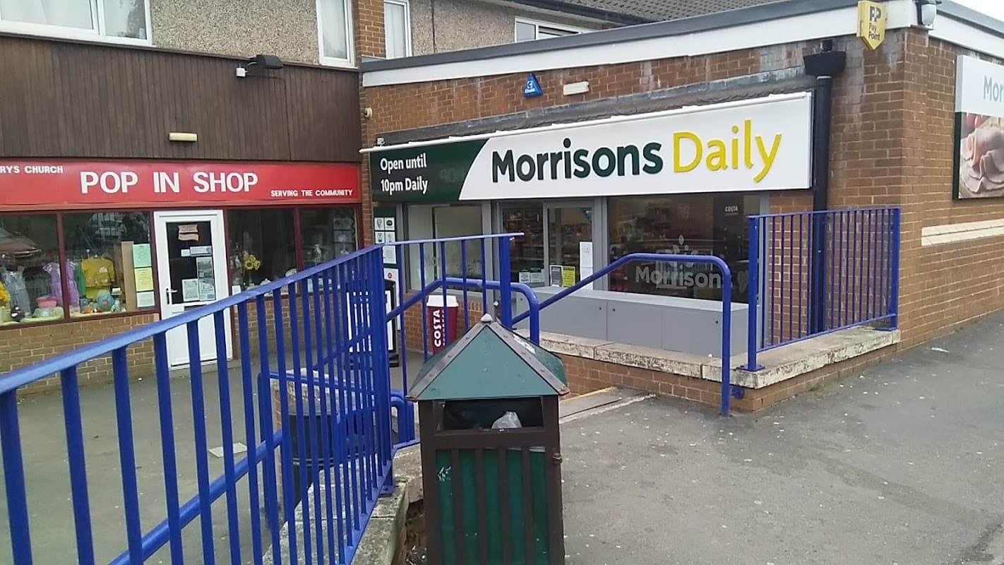 Morrisons Daily grocery store with a sign, open until 10 PM, next to a shop labeled "POP IN SHOP."