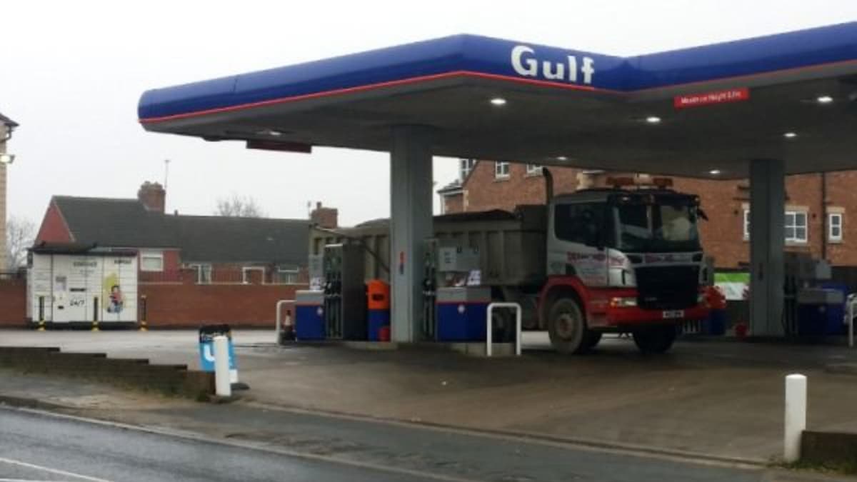 Gulf gas station with a truck parked, InPost Locker visible in the background, and residential buildings nearby.