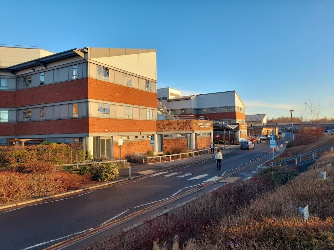 Car park with modern buildings, pedestrian walkways, and landscaped areas under a clear blue sky in Middlesbrough.