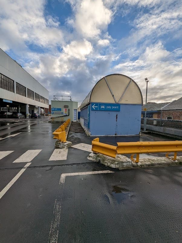 Multi-storey car park with a pay point, yellow barriers, and cloudy sky in Middlesbrough, Yorkshire.