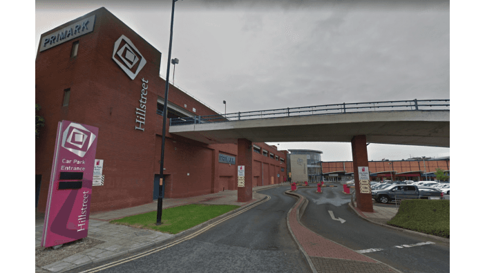 Car park entrance with signage, ramp, and buildings in a shopping area in Middlesbrough, Yorkshire.