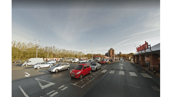 Pay & Display parking area in Middlesbrough with various parked cars and a supermarket in the background.
