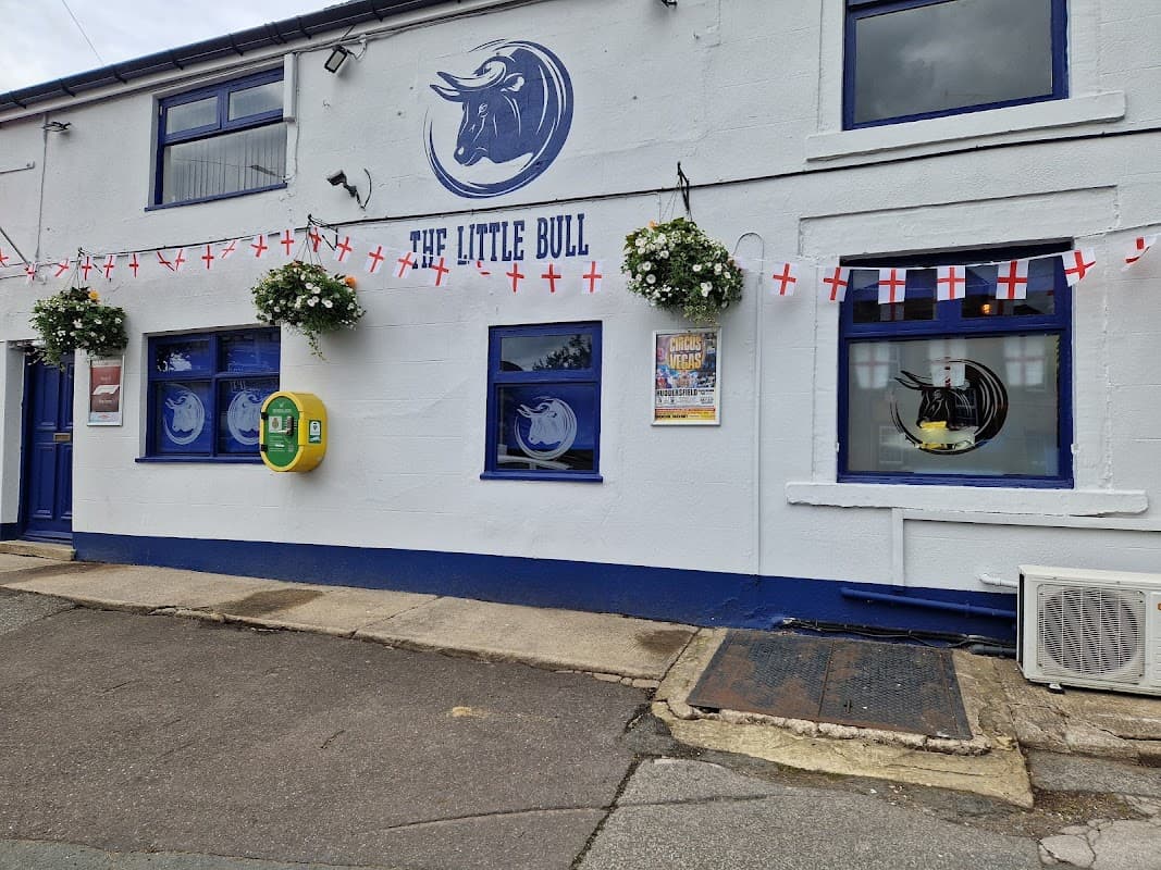 The Little Bull pub in Middlestown, Yorkshire, features blue windows, flower baskets, and English flags.