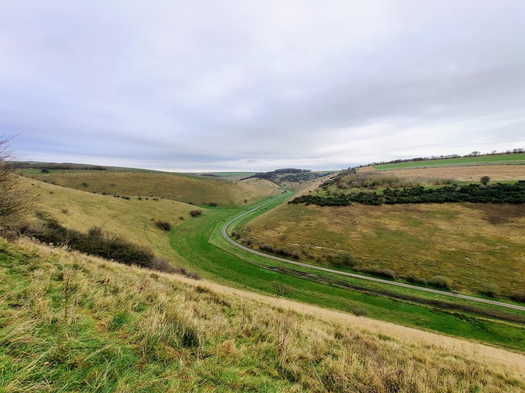 Rolling green hills and a winding road through Millington Pasture, under a cloudy sky in Yorkshire.