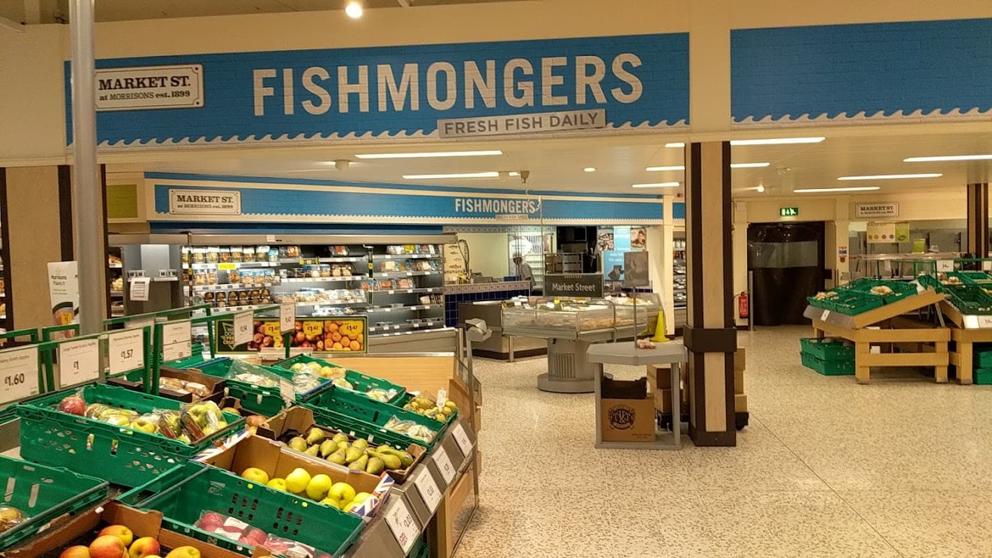 Morrisons shop interior featuring a fishmongers section and fresh produce displays with green baskets.