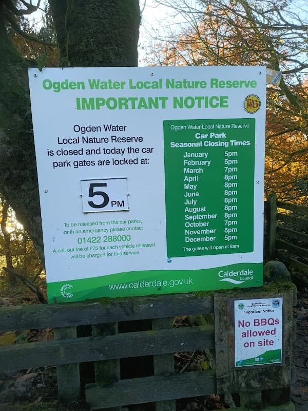 Sign detailing car park hours and important notices at Ogden Water Local Nature Reserve, Mixenden, Yorkshire.