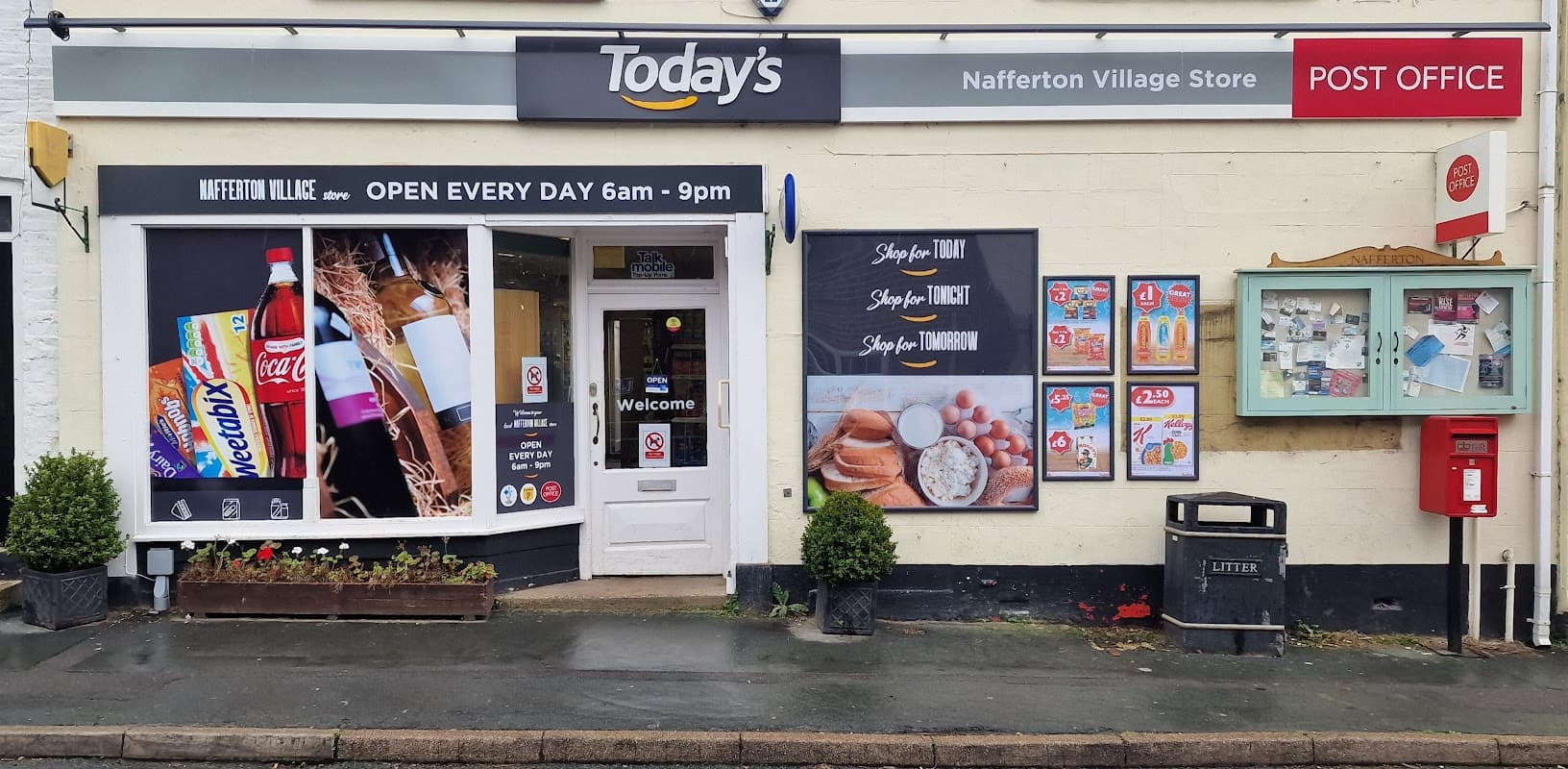 Londis store front with signage, open hours, and displays of drinks and snacks; post office and notice boards nearby.