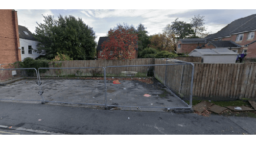 Pay & Display parking area with a fenced-off space, surrounded by trees and residential buildings in Nether Edge, Yorkshire.
