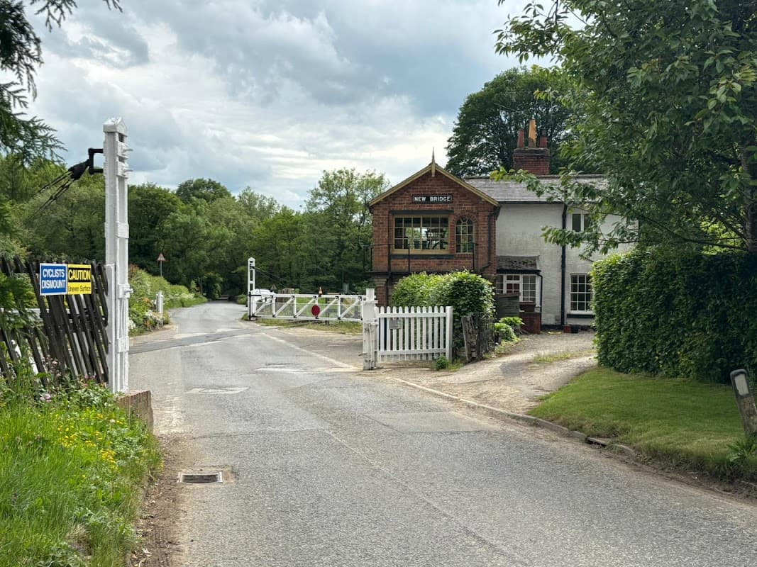 Quaint hotel with a sign reading "New Bridge," surrounded by greenery and a quiet road in Newton-upon-Rawcliffe.
