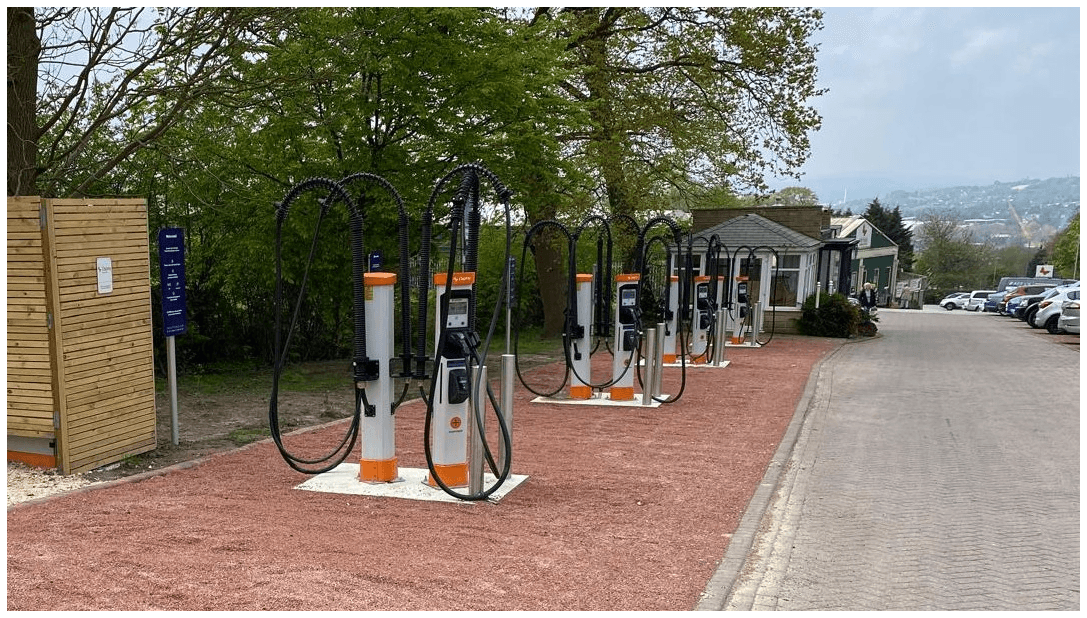 Osprey Charging Station with multiple electric vehicle chargers lined up along a gravel path in a green setting.
