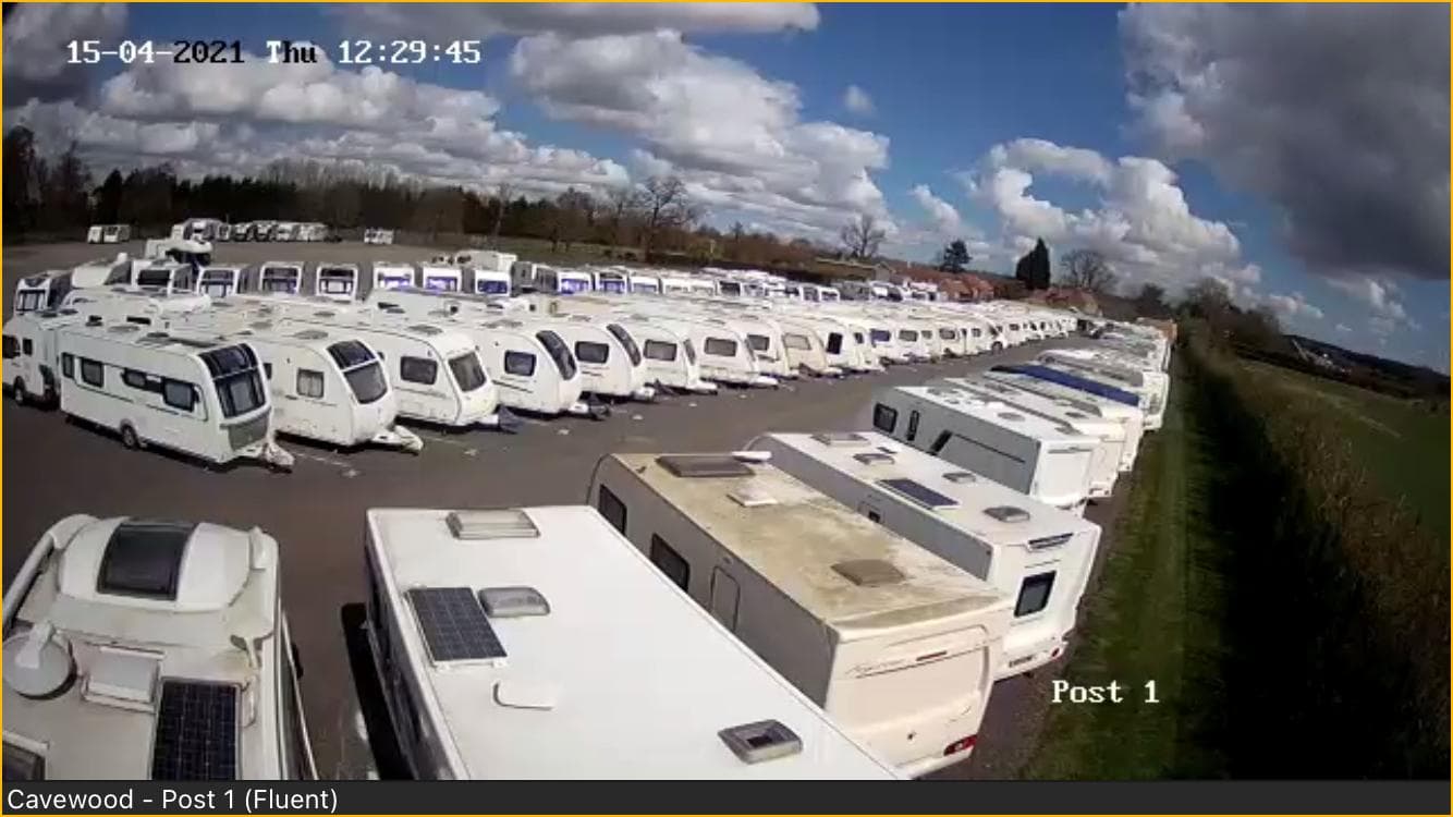 Numerous caravans and motorhomes parked in a storage area under a partly cloudy sky in North Cave, Yorkshire.