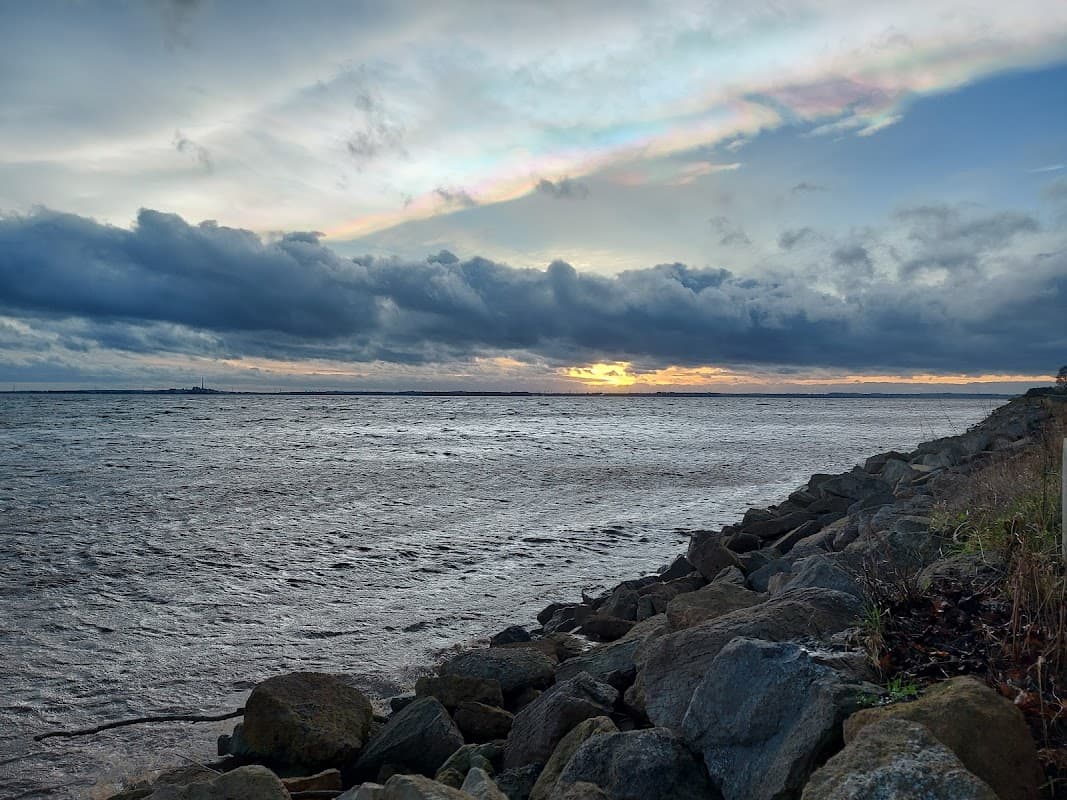 Carpark and viewing area by the river, with rocky shoreline and dramatic clouds at sunset in North Ferriby, Yorkshire.