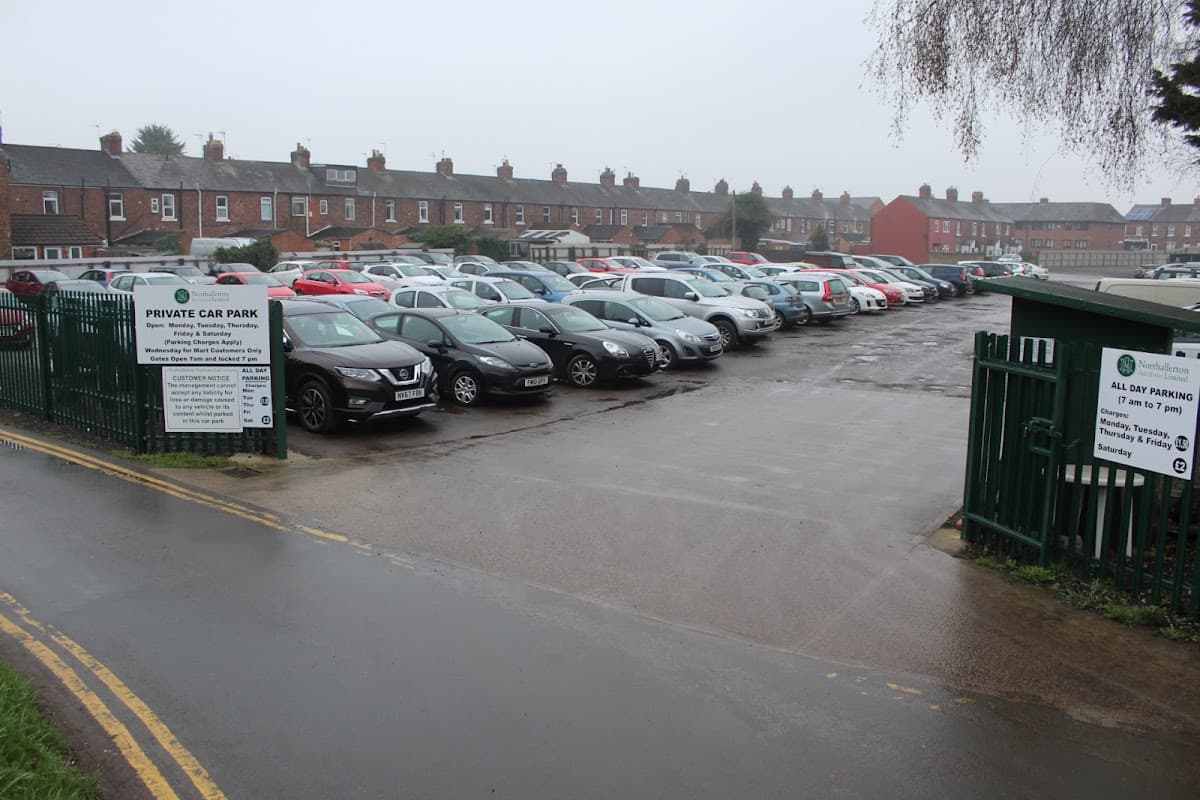 Pay & Display car park in Northallerton, lined with parked cars and residential buildings in the background.