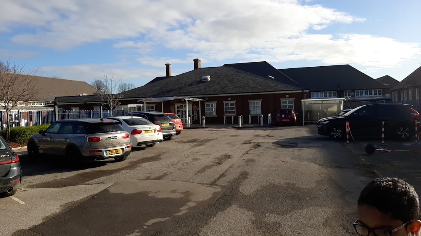 Tang Hall primary school and The Avenue Children's Centre car park with parked cars and a clear blue sky.