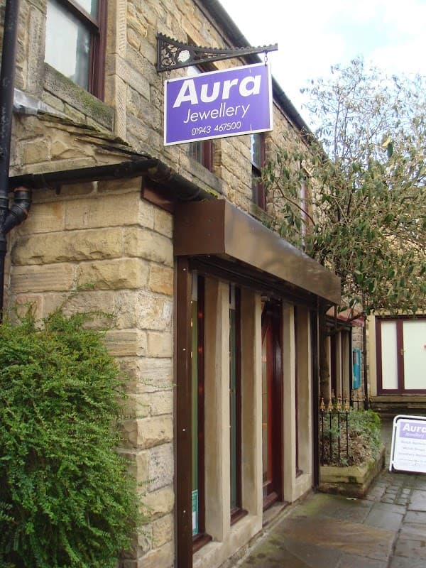 Aura Jewellery storefront with a blue sign, stone walls, and a small tree outside in Otley, Yorkshire.