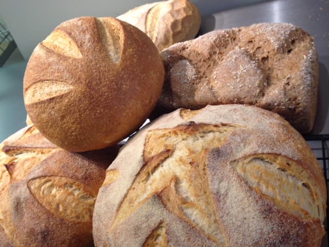 Freshly baked artisan breads with golden crusts, displayed on a cooling rack at Bondgate Bakery in Otley, Yorkshire.