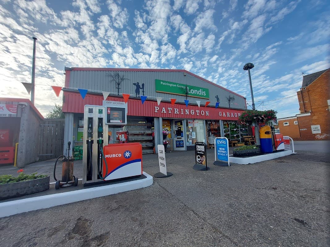 Patrington Garage with petrol pumps, a Londis sign, and colorful bunting under a blue sky.