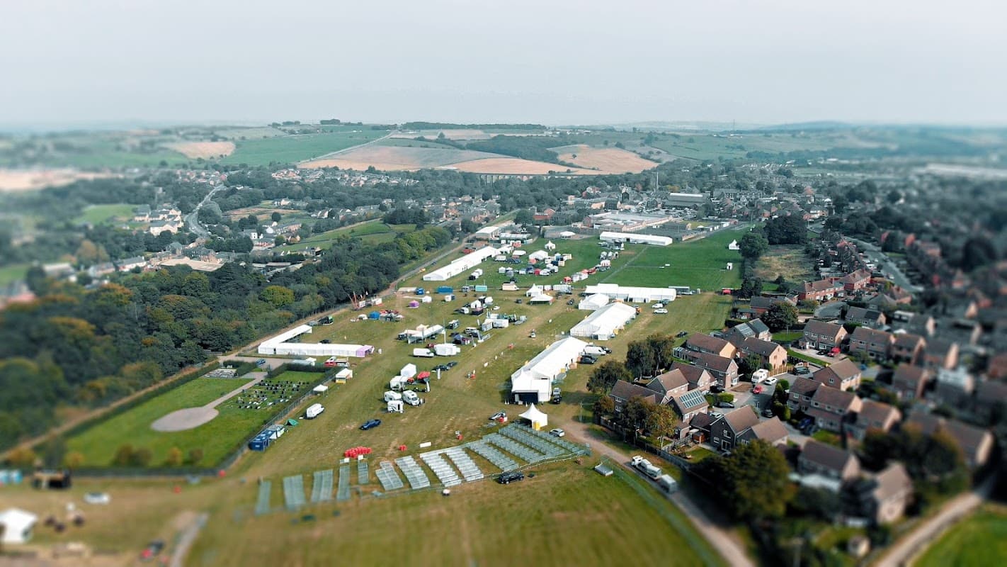 Aerial view of Penistone Show Ground featuring tents, green fields, and nearby residential areas in Yorkshire.