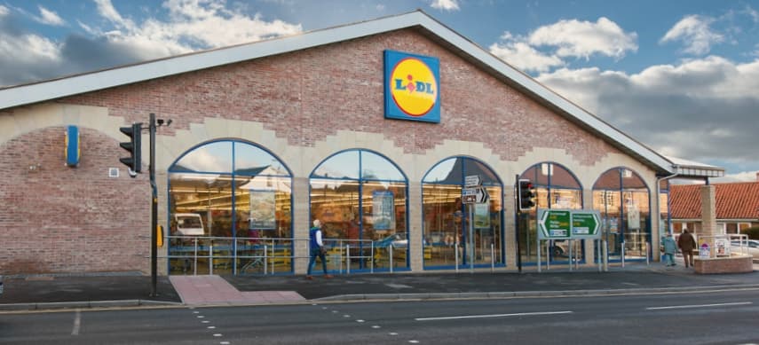 Lidl store in Pickering, Yorkshire, featuring large windows, a blue and yellow logo, and a cloudy sky backdrop.