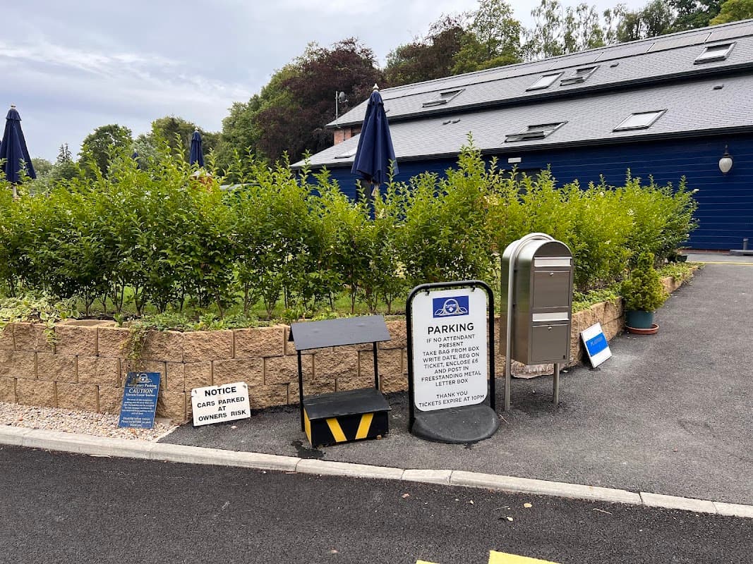 Platform 3 Car Park with signage, pay station, hedges, and umbrellas in a landscaped area in Pickering, Yorkshire.