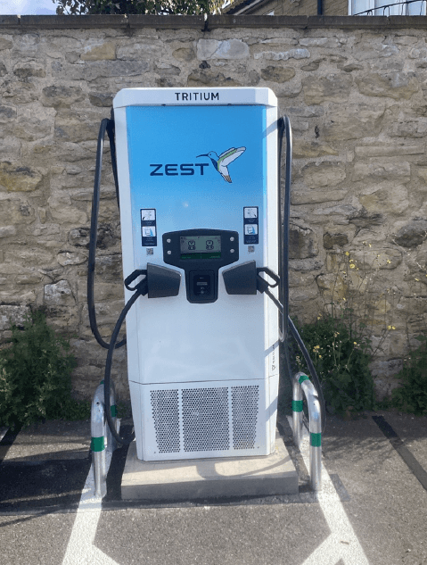 Zest Charging Station with a blue and white design, located against a stone wall in Pickering, Yorkshire.