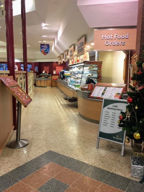 Interior of Morrisons featuring a café area, hot food counter, and festive decorations.