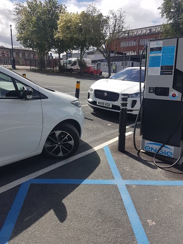 Pay & Display car park with two parked cars, one white and one silver, near charging station in Pontefract, Yorkshire.