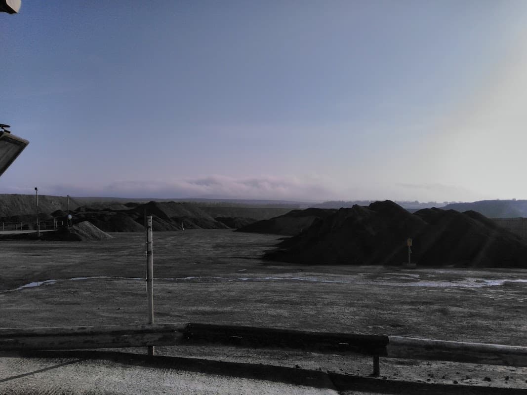 Dusty landscape with large heaps of aggregate material under a clear sky in Preston-Under-Scar, Yorkshire.