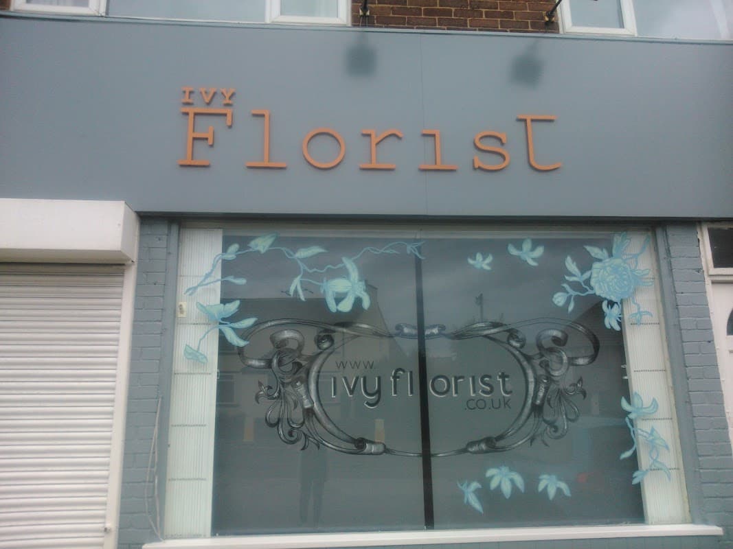 Signage for Ivy Florist with floral designs on the window and a website address displayed prominently.