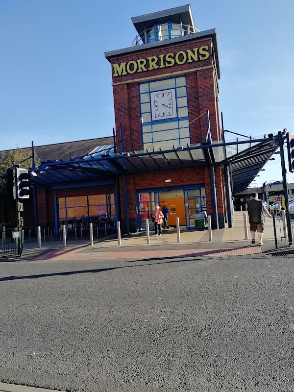 Morrisons Café building with a clock tower, large windows, and outdoor seating area in Redcar, Yorkshire.