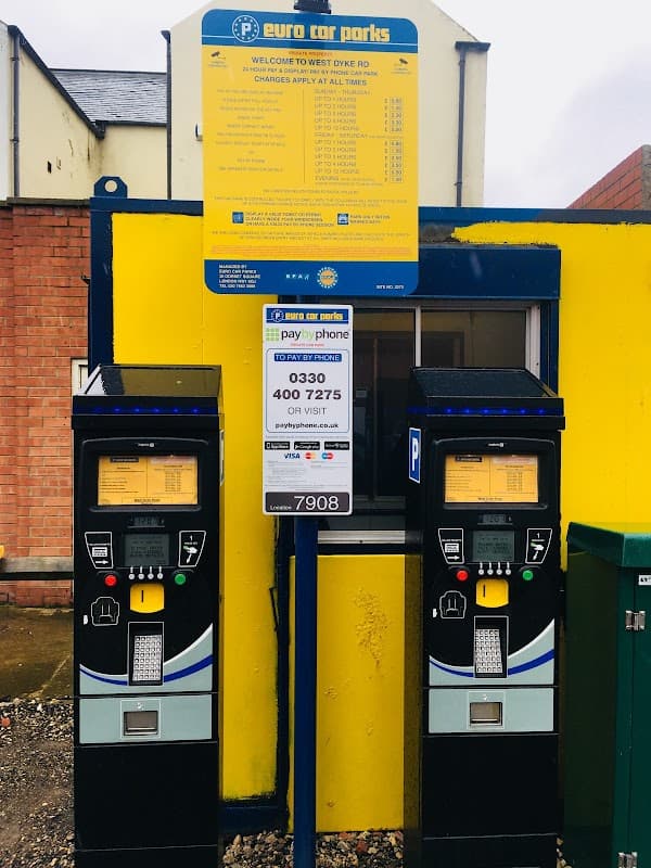 Pay & Display parking machines with a yellow sign detailing charges and contact information in Redcar and Cleveland.