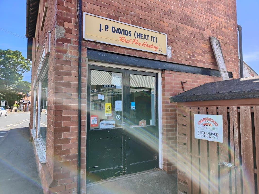 Brick storefront with "J P Davids (Heat It)" sign, featuring a door and window, in Riccall, Yorkshire.