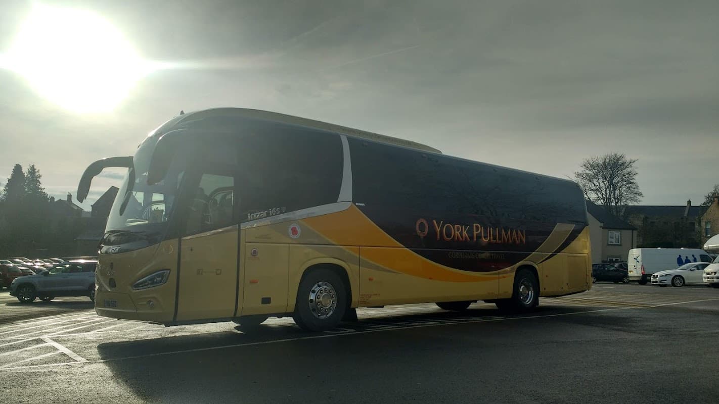A yellow and black York Pullman coach parked at Richmond Coach Park, with cloudy skies in the background.