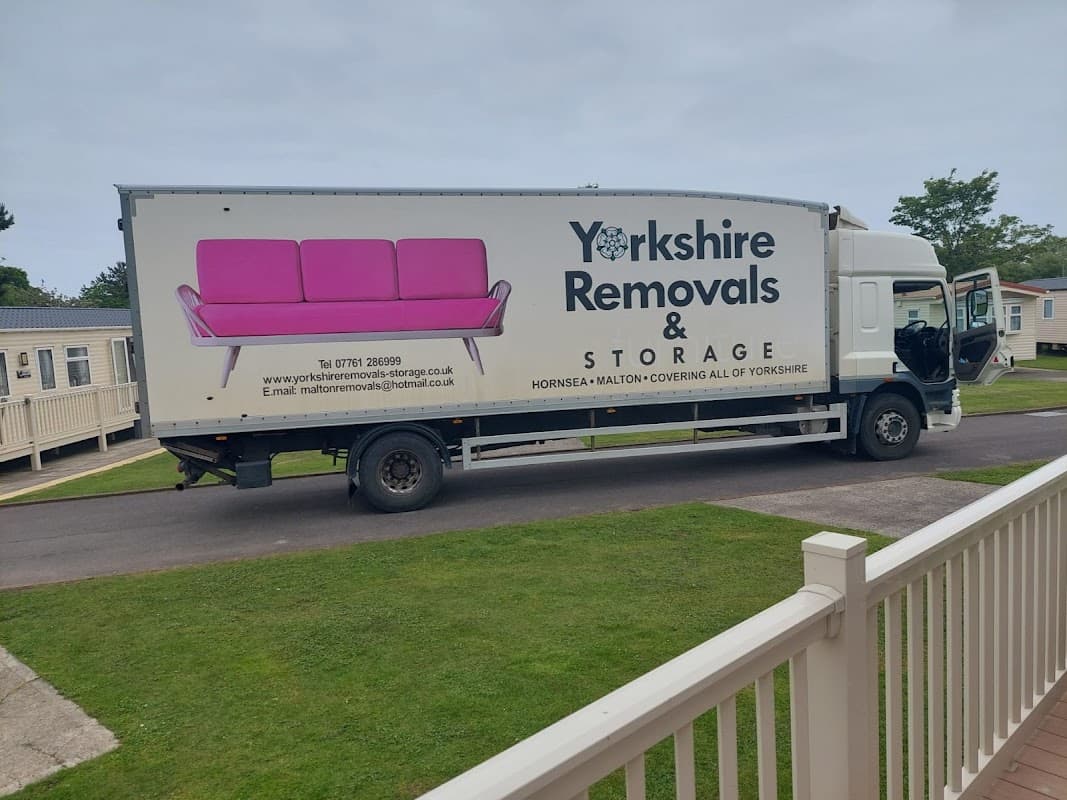 Yorkshire Removals & Storage truck parked, featuring a pink sofa graphic and contact details on the side.