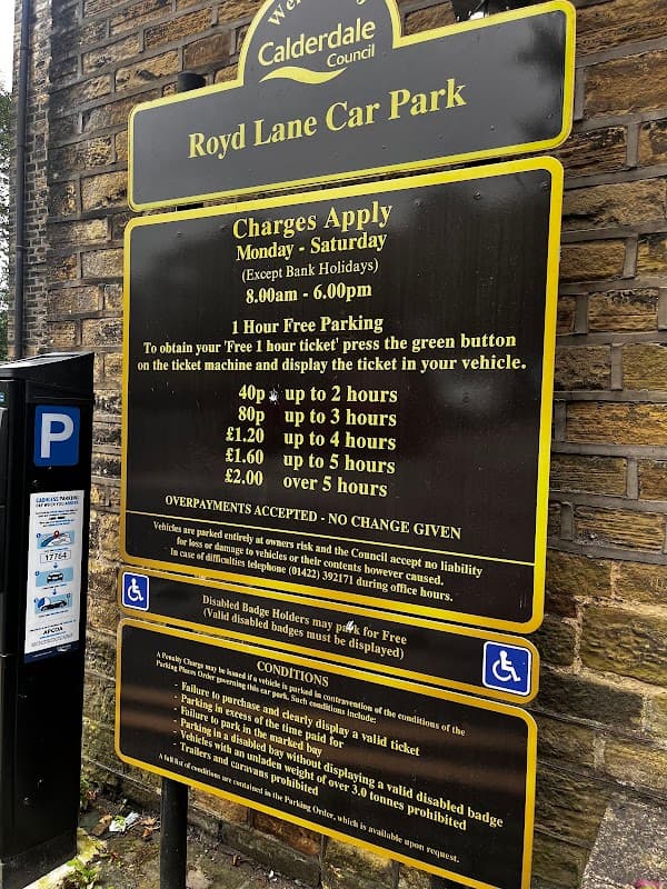 Sign for Royd Lane Car Park with parking charges, hours, and conditions displayed on a yellow and black background.