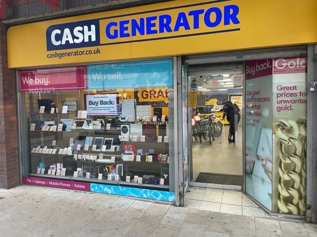 Storefront of Cash Generator in Rotherham, showcasing electronics for buy and sell, with promotional signs and displays.