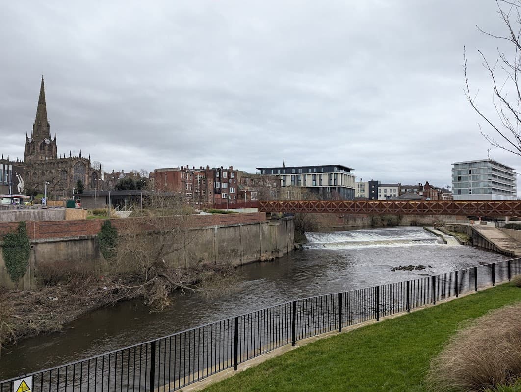 View of Forge Island Car Park with a river, bridge, and buildings, including a church spire in the background.