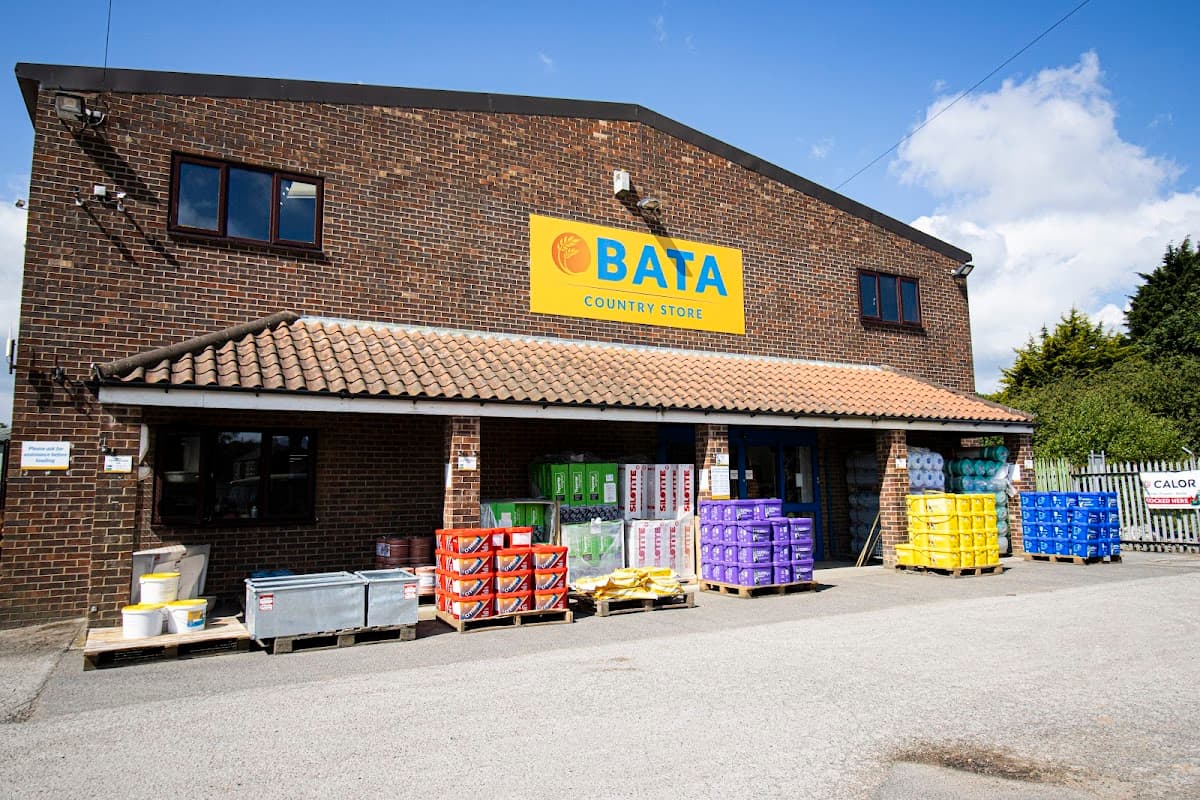 BATA Country Store with colorful crates and containers outside, set against a brick building under a blue sky.