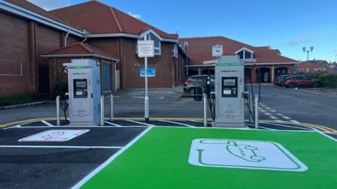 InstaVolt charging station with two chargers, green parking area, and a brick building in the background in Ruswarp, Yorkshire.