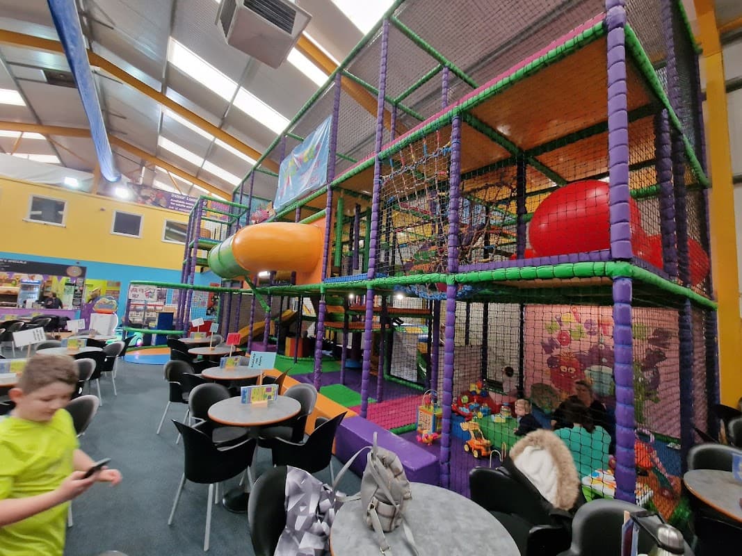 Colorful indoor play area with climbing structures, slides, and seating for parents in Ruswarp, Yorkshire.