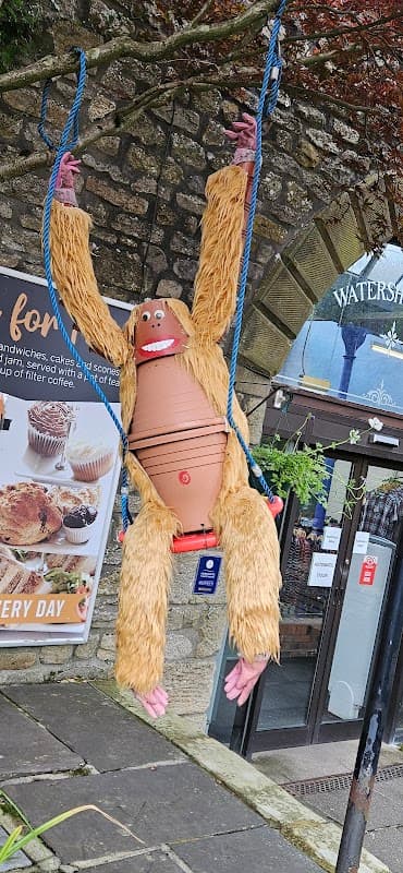 A large, furry orangutan decoration swings on a rope in front of Watershed Mill grocers in Settle, Yorkshire.