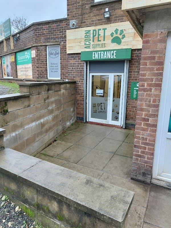 Entrance to Acorn Pet Supplies, featuring a glass door with "PET SUPPLIES" signage and a paw print logo.