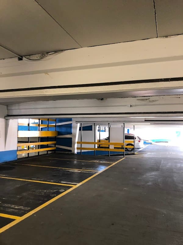 Empty car park with white and blue walls, yellow lines, and parked cars in Sheffield, Yorkshire.