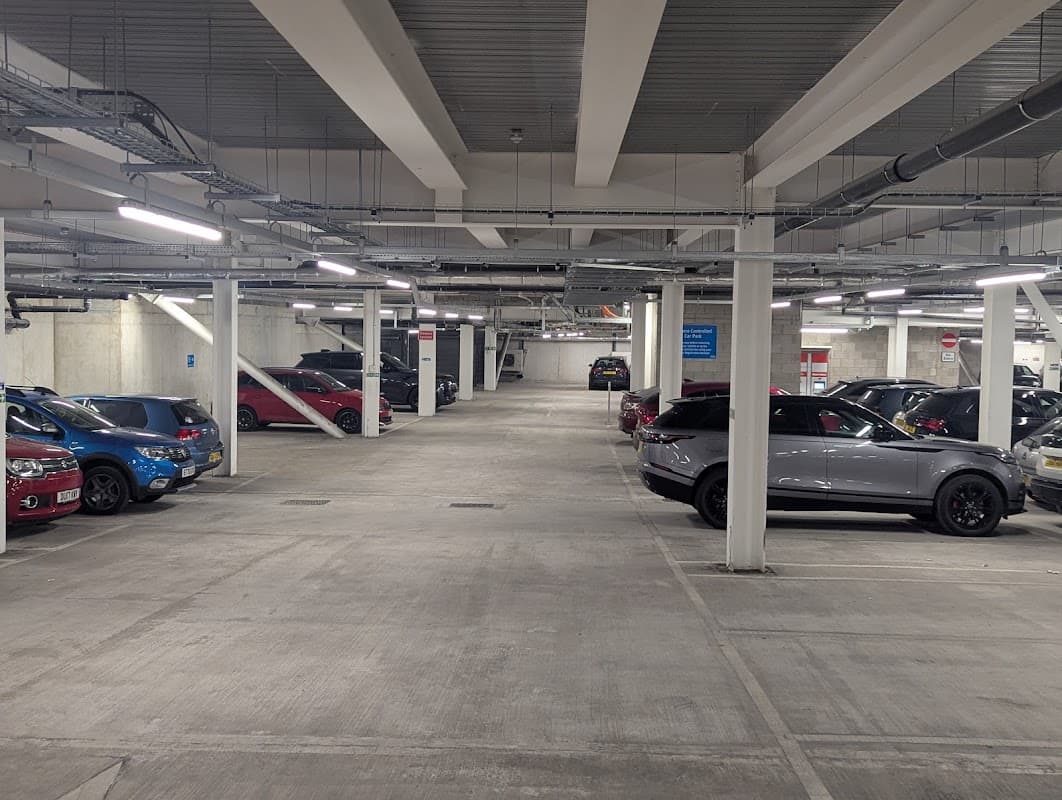 Spacious underground car park with parked cars and bright overhead lighting at New Era Square, Sheffield.