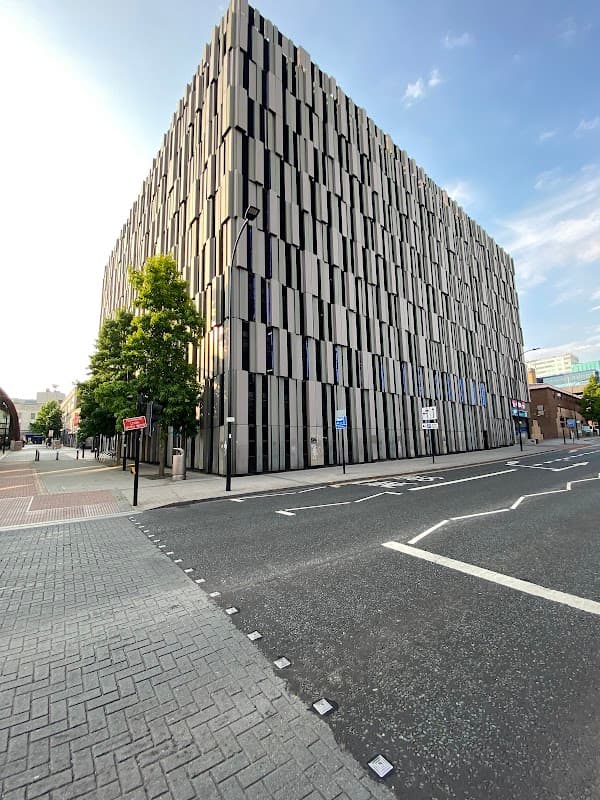 Modern multi-story car park with a textured facade, located at The Moor in Sheffield, Yorkshire, under a clear blue sky.